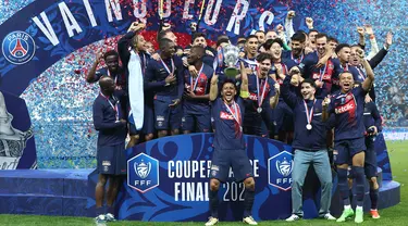 Bek Paris Saint-Germain #05 Marquinhos (tengah) mengangkat trofi Coupe de France 2023/2024 saat berselebrasi dengan timnya setelah menang atas Olympique Lyon pada laga final di Stadion Pierre-Mauroy, Minggu (26/5/2024) dini hari WIB. (FRANCK FIFE / AFP)