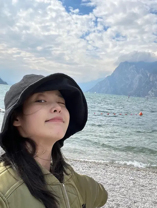 Dengan busana kasual, IU juga menikmati pemandangan tepi laut.  [Foto: Instagram/ dlwlrma]