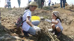 Dua anak membersihkan sampah di pantai timur ancol, Jakarta, Minggu (18/8/2019).  Gerakan Menghadap Laut 2.0 akan digelar serentak di lebih dari 100 titik lokasi di seluruh Indonesia. (Liputan6.com/Herman Zakharia)