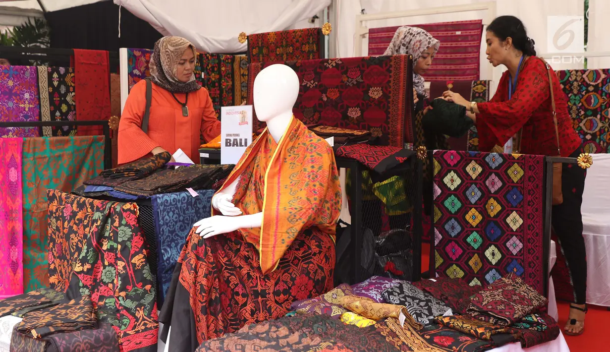 Pengunjung melihat-lihat produk kain tenun yang dipamerkan di Festival Sarung Indonesia 2019, Plaza Tenggara Kompleks GBK, Jakarta, Minggu (3/3). Festival ini diikuti sejumlah perajin sarung tenun dari berbagai daerah. (Liputan6.com/Helmi Fithriansyah)