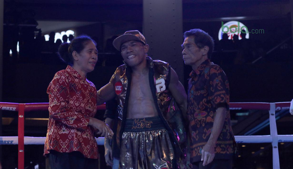 Jansen Marapu menyapa orang tuanya usai menang atas petinju Thailand, Phuttiphong Rakoon pada kelas Lightweight Mahkota Boxing Super Series di Cilandak Town Square, Jakarta (10/3/2018). Jansen menang TKO pada ronde ke sembilan. (Bola.com/Nick Hanoatubun)