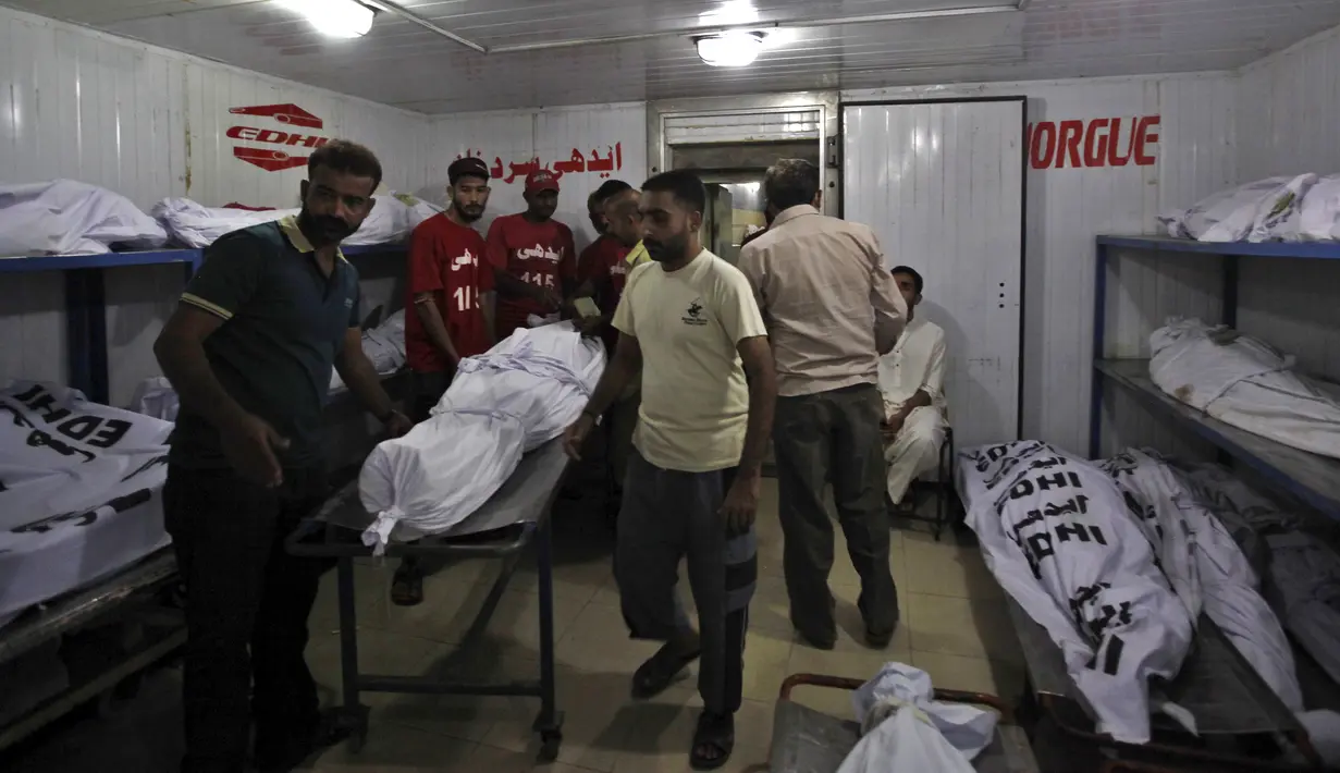 Relawan memindahkan tubuh salah satu jenazah korban gelombang panas usai diidentifikasi, di sebuah kamar mayat di Karachi, Pakistan, Senin (22/6/2015). (REUTERS/Akhtar Soomro)