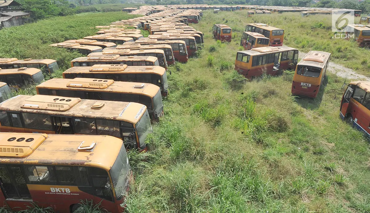 Deretan  bus Transjakarta yang sudah tidak digunakan lagi diparkir di lahan kosong di Dramaga, Kabupaten Bogor, Jawa Barat, Minggu (28/7/2019). Kurang lebih 300 bus Transjakarta dengan kondisi tak terawat diparkir di lahan kosong sejak 2018. (merdeka.com/Arie Basuki)
