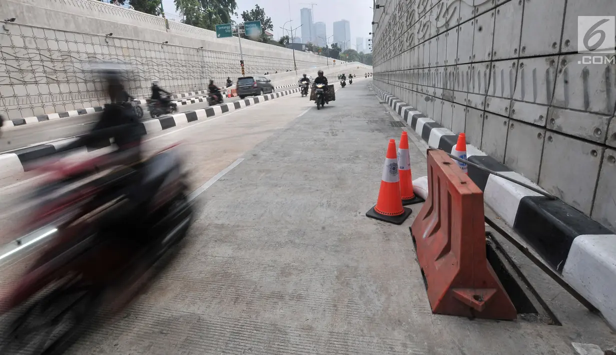 Kendaraan melintas di dekat penutup lubang saluran air yang kembali hilang di Underpass Mampang-Kuningan, Jakarta, Kamis (23/8). Dua buah steel grating atau besi penutup saluran air hilang dicuri orang tak dikenal. (Merdeka.com/Iqbal S. Nugroho)