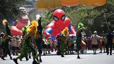 Para pengunjung tampil di depan balon Spiderman di Alameda Avenue, Santiago, Chile pada 1 Desember 2024. (RODRIGO ARANGUA/AFP)