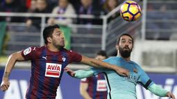 Pemain FC Barcelona, Arda Turan  (kanan) berebut bola dengan pemain Eibar, Mauro dos Santos pada lanjutan La Liga Spanyol di Municipal de Ipurua, Eibar, (22/1/2017). Barcelona menang 4-0. (EPA/Juan Herrero)