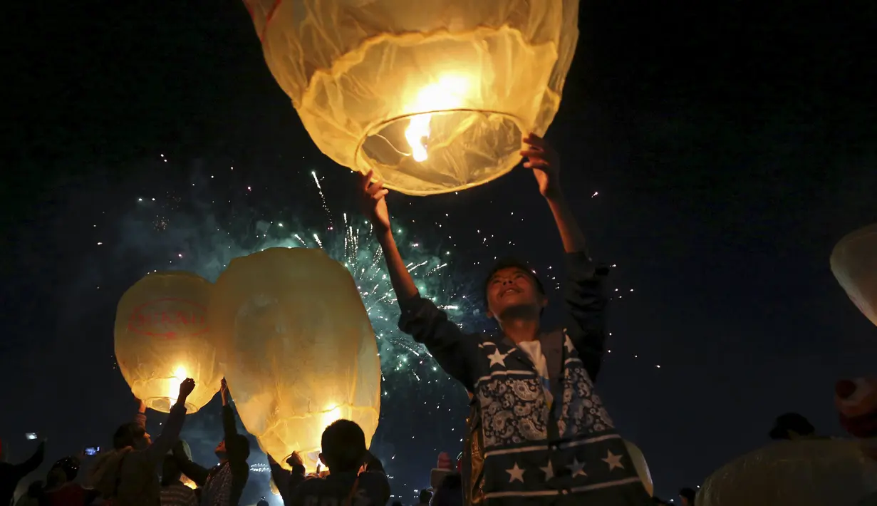 Sejumlah warga saat menerbangkan lampion buatan tradisional ke langit selama festival tahunan Tazaungdaing di Taunggyi, Myanmar (19/11). (REUTERS/Soe Zeya Tun)