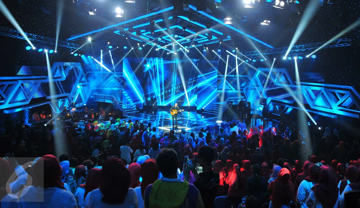 Penampilan Rick Price sambil bergitar acara Golden Memories International di studio Indosiar, Jakarta, Senin (9/1). (Liputan6.com/Angga Yuniar)