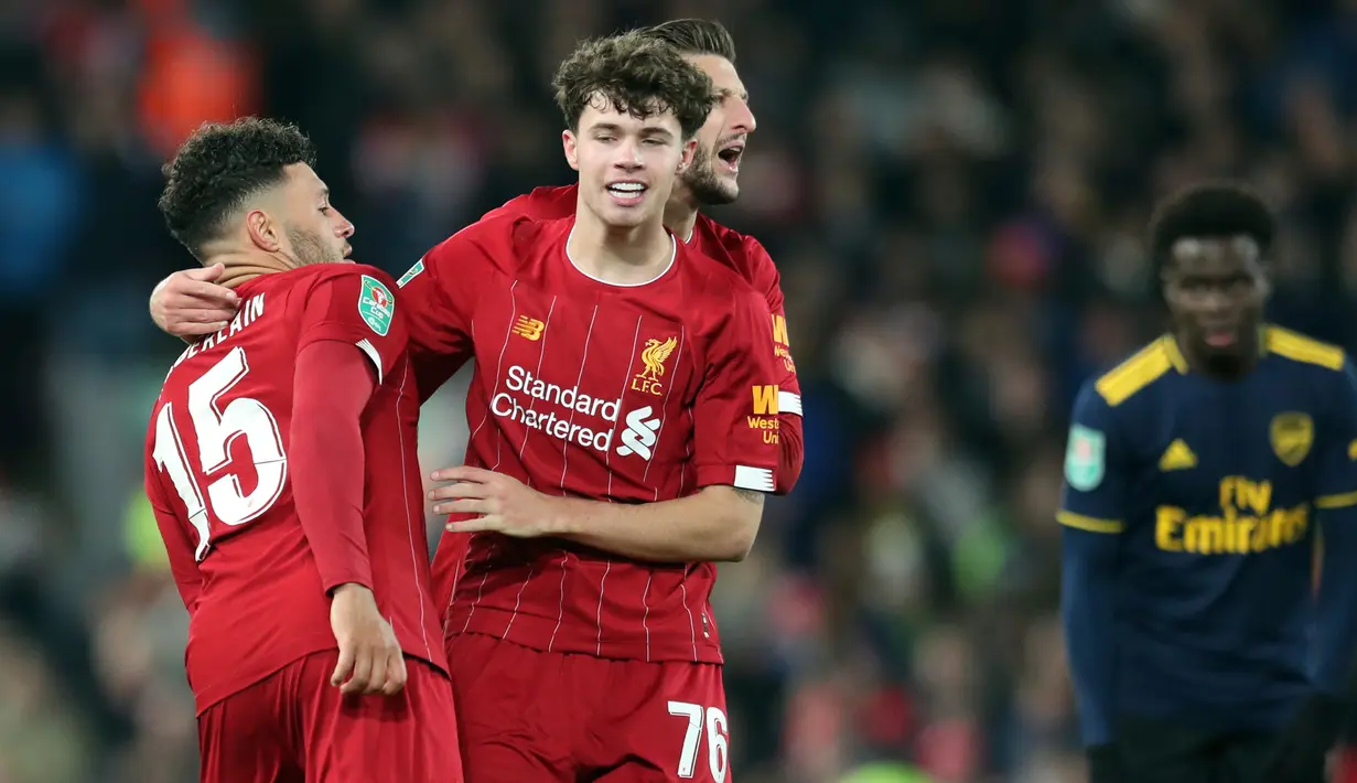 Gelandang Liverpool, Alex-Oxlade Chamberlain berselebrasi dengan rekan setimnya setelah mencetak gol ke gawang Arsenal pada laga babak 16 Besar Carabao Cup di Anfield Stadium, Rabu (30/10/2019). Berimbang 5-5 di waktu normal, Liverpool menang 5-4 dalam adu penalti. (AP/Jon Super)