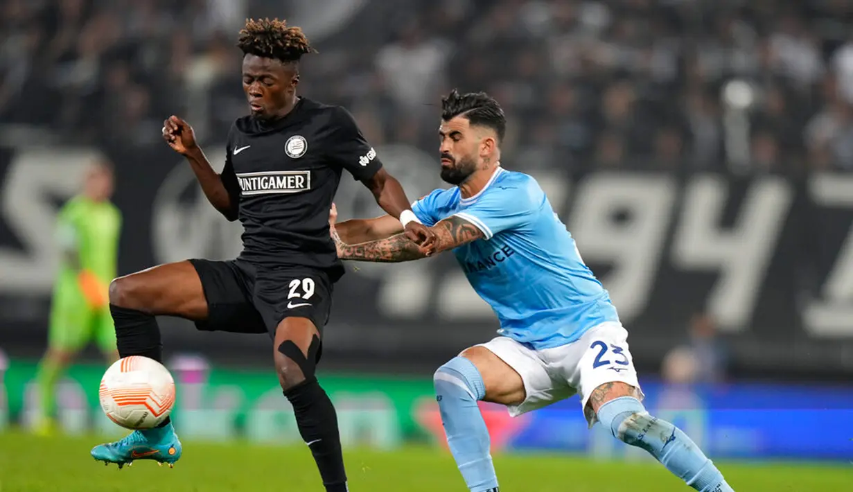 Pemain Sturm Graz Mohammed Fuseini (kiri) berebut bola dengan pemain Lazio Elseid Hysaj pada pertandingan sepak bola Grup F Liga Europa di Merkur Arena, Graz, Austria, 6 Oktober 2022. Pertandingan berakhir imbang 0-0. (AP Photo/Florian Schroetter)