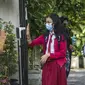 Seorang siswa menjalani pemeriksaan suhu tubuh saat memasuki sekolah sebelum mengikuti pembelajaran tatap muka (PTM) di sebuah sekolah di Surabaya, Jawa Timur, Senin (6/9/2021). Pemerintah kembali membuka sekolah di tengah pandemi COVID-19. (JUNI KRISWANTO/AFP)