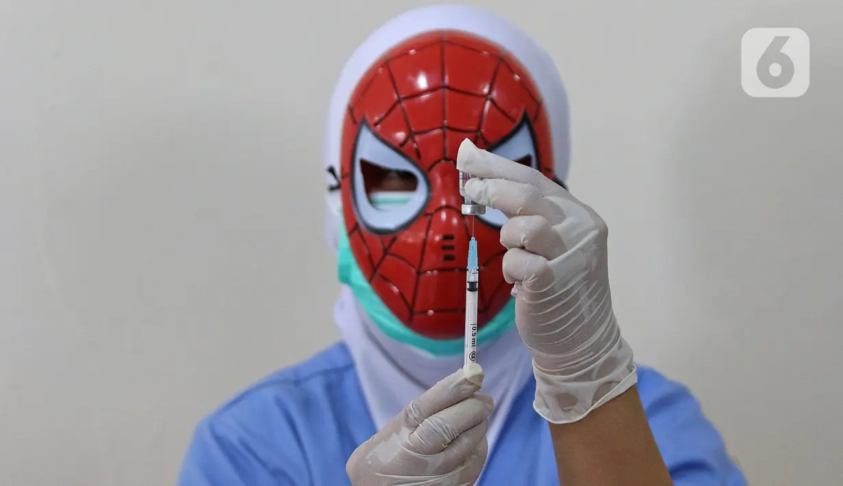 Seorang tenaga kesehatan bertopeng superhero menyiapkan vaksin covid-19 saat vaksinasi anak usia 6-11 tahun di RSIA Tambak, Jakarta, Rabu (22/12/2021). Penggunaan topeng superhero dimaksudkan untuk menarik minat anak-anak yang mengikuti vaksinasi. (Liputan6.com/Herman Zakharia)