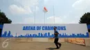 Seseorang melintas di depan banner arena champions di Istora Senayan, Jakarta, Jumat (7/8/2015). Jelang perhelatan Kejuaraan Bulutangkis Dunia 2015, sejumlah persiapan terus dilakukan pihak panitia pelaksana. (Liputan6.com/Helmi Fithriansyah)