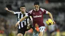 Bek West Ham United, Nayef Aguerd (kanan) berebut bola dengan gelandang Newcastle United, Miguel Almiron pada laga Liga Inggris 2022/2023 di St James' Park, Newcastle (4/2/2023). Sebagai bek, Nayef Aguerd sempat ingin mengenakan nomor punggung 6 bersama West Ham usai didatangkan dari Rennes. Namun karena nomor tersebut telah dipensiunkan untuk mengenang legenda klub, Bobby Moore, jadilah ia memilih nomor punggung 27 sebagai bentuk janjinya kepada rekannya di Maroko. (AFP/Oli Scarff)