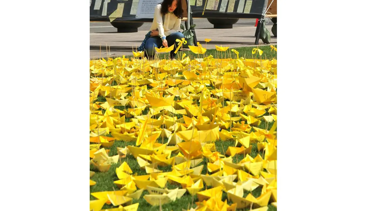 Di Balai Kota Seoul, seorang warga meletakkan kapal kertas kuning pada peringatan bagi korban feri 'Sewol', Rabu (7/5/14). (AFP PHOTO/JUNG YEON-JE)