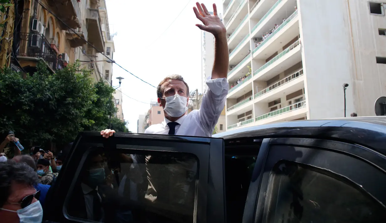 Presiden Prancis Emmanuel Macron melambaikan tangan saat mengunjungi lokasi ledakan di Beirut, Lebanon, Kamis (6/8/2020). Presiden Macron menjadi pemimpin dunia pertama yang mengunjungi Lebanon, usai ledakan besar menghancurkan Beirut pada Selasa (4/8) lalu. (AP Photo/Thibault Camus, Pool)