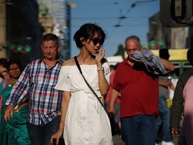 Wanita yang biasa dipanggil Gista ini terlihat cantik saat berjalan di kerumunan orang. Menggunakan pakaian berwarna putih dilengkapi jam tangan dan kacamata hitam, ia tampak sedang memegang kamera di tangan kanannya. (Liputan6.com/IG/@gistaputri)