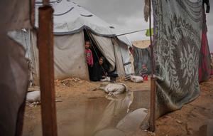 Nanaa Abu Jari memasak di luar tendanya setelah tenda tersebut terendam air hujan di Nuseirat, Jalur Gaza tengah, Jumat, 2 Januari 2026. Hingga awal Januari 2026, wilayah Gaza masih dihantam cuaca ekstrem yang memperparah krisis kemanusiaan di sana. (AP Photo/Abdel Kareem Hana)