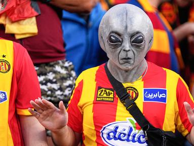 Seorang suporter Esperance de Tunis menggunakan topeng alien saat mendukung timnya melawan Flamengo pada pertandingan Piala Dunia Antarklub 2025 di Lincoln Financial Field, Philadelphia, Selasa (17/6/2025). (AP Photo/Chris Szagola)