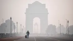 Seorang pria melintas di sepanjang jalan Rajpath dekat Gerbang India di tengah kondisi asap tebal yang menyelimuti sehari setelah perayaan Diwali, festival cahaya Hindu, di New Delhi pada Minggu (15/11/2020). (Photo by Sajjad HUSSAIN / AFP)