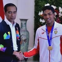 Presiden Joko Widodo atau Jokowi (kiri) bersalaman dengan sprinter Lalu Muhammad Zohri (kanan) di Istana Bogor, Jawa Barat, Rabu (18/7). Zohri tampak mengenakan medali emas yang diraihnya di Finlandia. (Liputan6.com/Pool/Biro Pers Setpres)