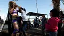 Pegulat Jerman 'Diosa del Rhin' (Dewi Rhin) bersama sejumlah bocah saat aksi kesetaraan gender di Ciudad Juarez, Meksiko (13/3/2016). Selain pegulat, Rhin juga merupakan seorang aktivis perempuan. (Reuters/Jose Luis Gonzalez)