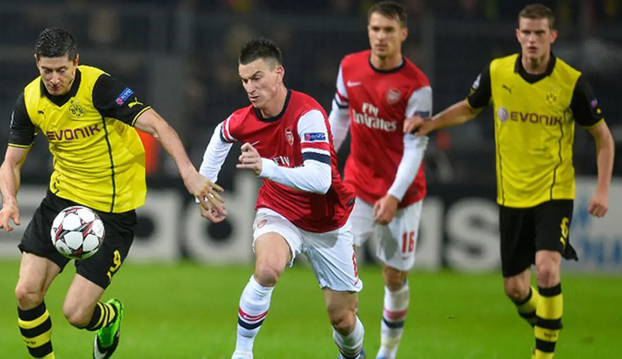 Robert Lewandowski dan Laurent Koscielny bersaing merebutkan bola pada Liga Champions Grup F antara Borussia Dortmund vs Arsenal di Dortmund,(6/11/2013).(AFP/Odd Andersen)