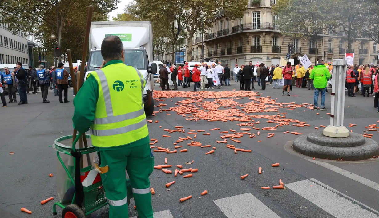 Sejumlah wortel berhamburan di jalanan depan Kementerian Kesehatan, Paris, Rabu (4/10). Aksi ini merupakan bentuk kekecewaan para penjual tembakau dengan rencana pemerintah untuk menaikan harga rokok. (AFP PHOTO/JACQUES DEMARTHON)