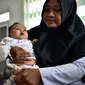 Petugas menyuntikan Vaksin Campak dan Rubella (MR) kepada bayi saat dilakukan imunisasi di sebuah puskesmas, Banda Aceh, Rabu (19/9). Pelaksanaan vaksinasi MR di Aceh sempat ditunda karena adanya enzim babi di dalam vaksin. (CHAIDEER MAHYUDDIN / AFP)