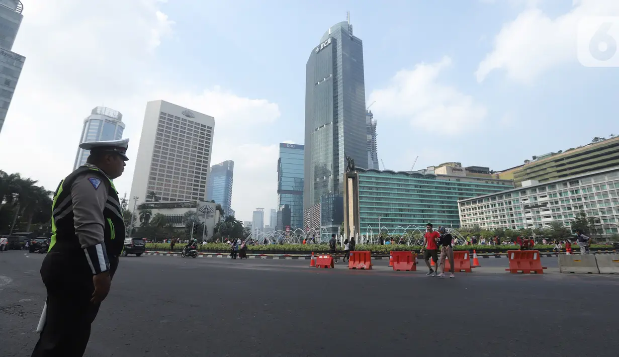 Petugas kepolisian berjaga di kawasan Bundaran HI, Jakarta, Minggu (20/10/2019). Car free day (CFD) ditiadakan Minggu (20/10) ini dalam rangka pelantikan Presiden dan Wapres periode 2019-2024, Joko Widodo dan Ma'aruf Amin di Kompleks Parlemen, Senayan, Jakarta. (Liputan6.com/Herman Zakharia)