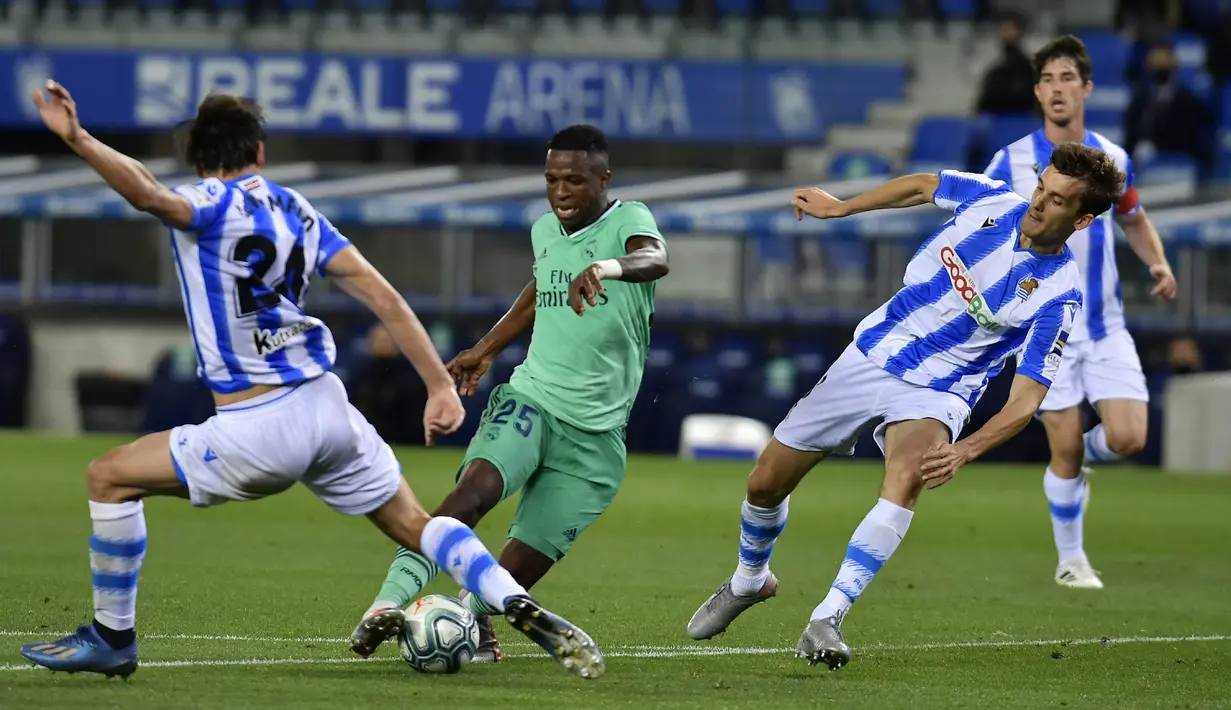 Pemain Real Madrid Vinicius Junior menggiring bola melewati pemain Real Sociedad Robin Le Normand pada pertandingan La Liga di Stadion Anoeta, San Sebastian, Spanyol, Minggu (21/6/2020). Real Madrid memuncaki klasemen sementara La Liga usai mengalahkan Real Sociedad 2-1. (AP Photo/Alvaro Barrientos)