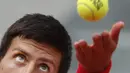 Ekspresi wajah petenis Serbia, Novak Djokovic melakukan servis saat melawan petenis Spanyol, Jaume Munar pada ajang Prancis Terbuka 2018 di Roland Garros stadium, Paris, France, (30/5/2018). (AP/Christophe Ena)