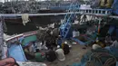 Nelayan duduk di atas kapal saat mereka berdoa sebelum berbuka puasa selama bulan suci Ramadhan di galangan kapal di kota pelabuhan Karachi, Pakistan pada 18 April 2022. Setelah menjalani ibadah puasa, waktu buka puasa menjadi momen yang dinanti oleh umat Islam. (Rizwan TABASSUM / AFP)