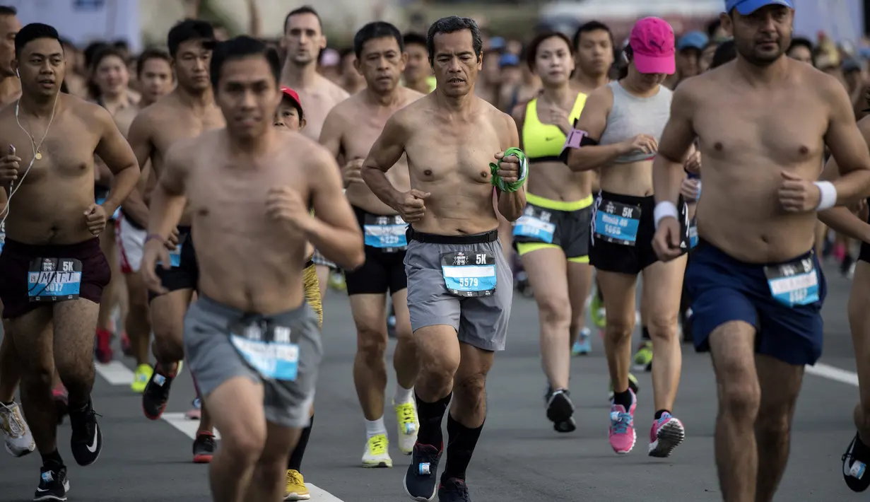 Peserta berlari dengan bertelanjang dada saat berpartisipasi pada The "Underpants Run" di Manila, Filipina, 8 April 2018. Ratusan orang hanya mengenakan pakaian yang minim berlari di sekitar distrik perbelanjaan kelas atas Manila. (NOEL CELIS / AFP)