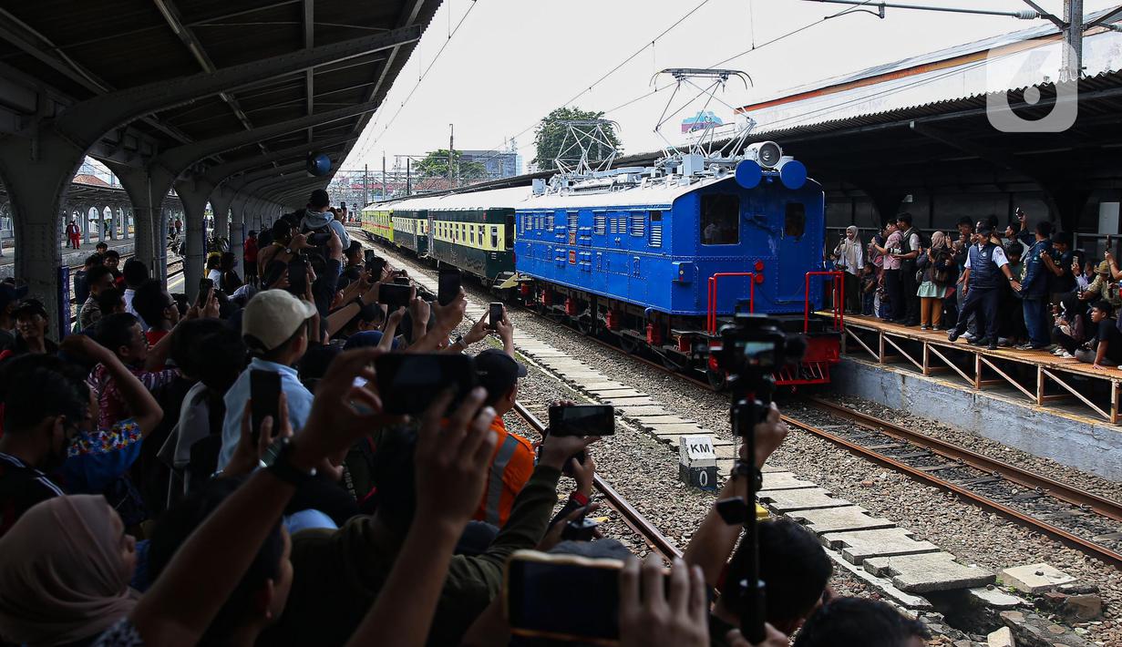 Warga menyaksikan rangkaian lokomotif listrik ESS 3200 tahun pembuatan 1927 saat memasuki peron pada perayaan 100 tahun operasional Kereta Rel Listrik (KRL) di Stasiun Jakarta Kota, Selasa (22/4/2025). (Liputan6.com/Angga Yuniar)