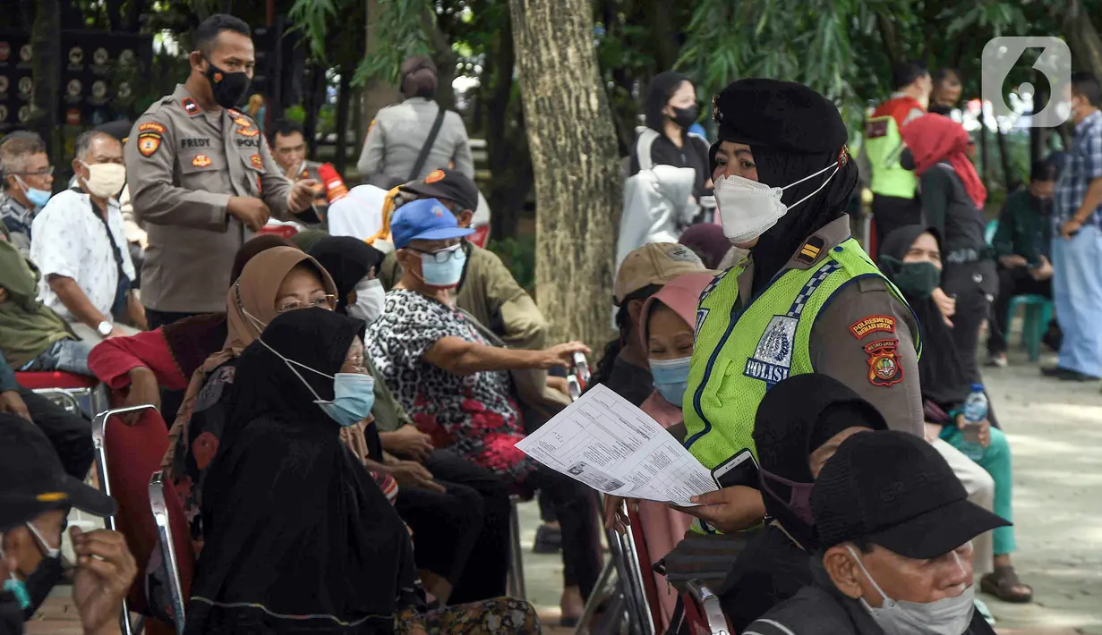 Polisi berjalan di antara warga lansia yang sedang menunggu untuk disuntik vaksin Sinovac di Alun-Alun Bekasi, Jawa Barat, Rabu (23/2/2022). Sebanyak 600 dosis vaksin Sinovac disiapkan pemerintah setempat untuk warga lansia guna mencegah penyebaran COVID-19. (Liputan6.com/Herman Zakharia)