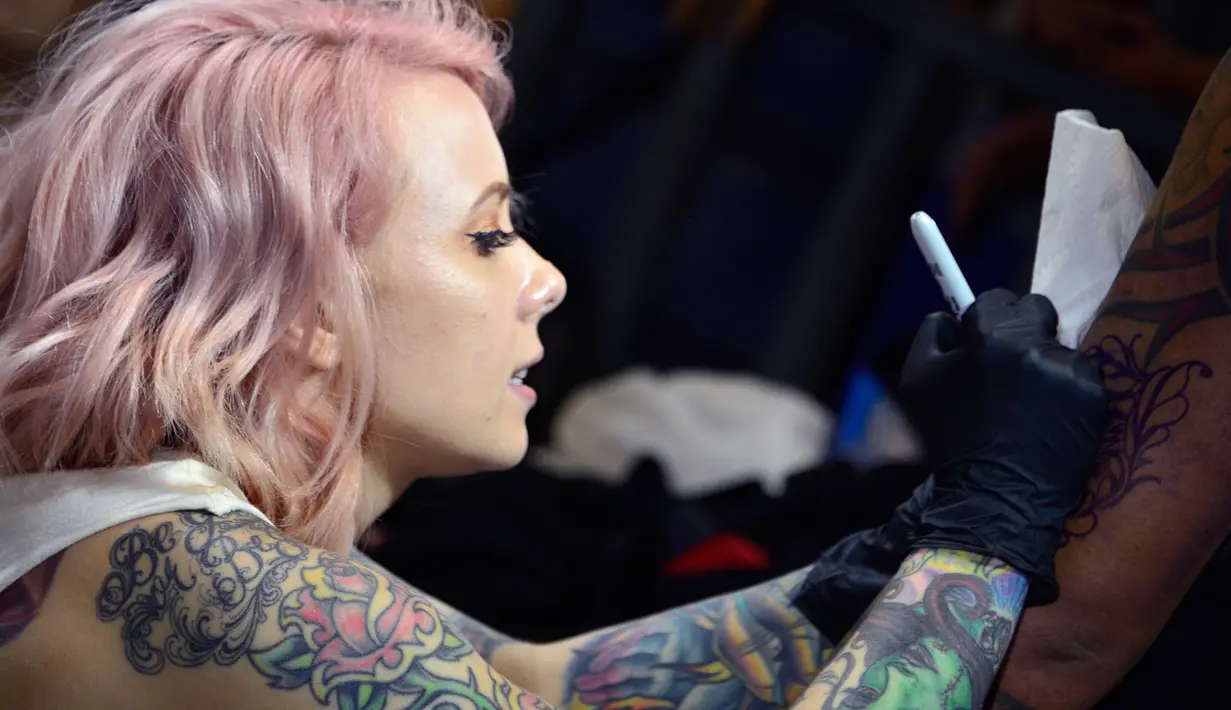 Seniman Megan Massacre membuat tato saat berpartisipasi dalam "New York Ink" di edisi 5 Konvensi Internasional Paradise Tatto, di San Antonio de Belen, San Jose, (8/5). Lebih dari 300 seniman tato berpartisipasi di acara ini.(AFP PHOTO/Ezequiel Becerra)