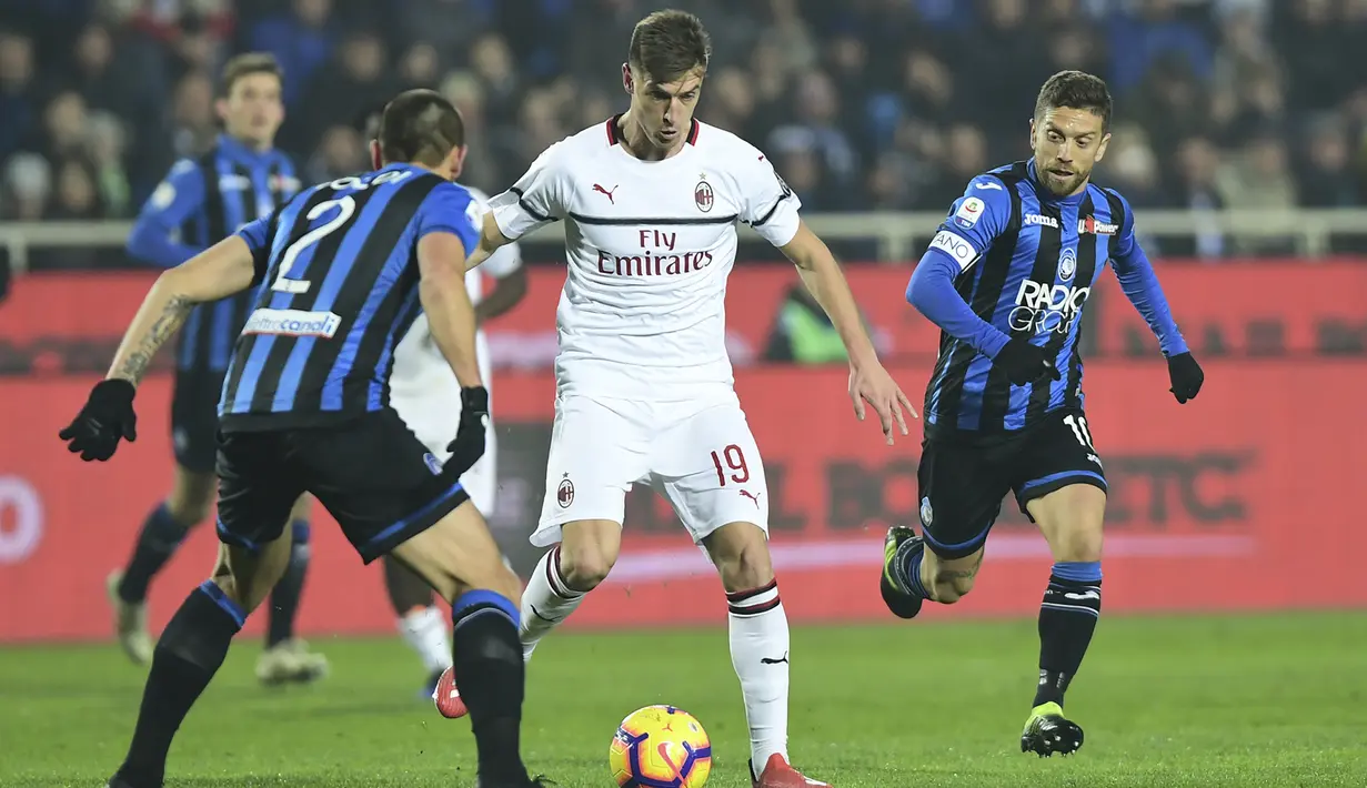 Striker AC Milan, Krzysztof Piatek, berusaha melewati hadangan bek Atalanta, Rafael Toloi, pada laga Serie A di Stadion Atleti Azzurri d'Italia di Bergamo, Sabtu (16/2). Atalanta kalah 1-3 dari Milan. (AFP/Miguel Medina)