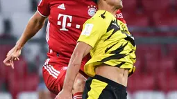 Bek Bayern Munchen, Benjamin Pavard berebut boal dengan pemain Borussia Dortmund Mahmoud Dahoud pada laga Piala Super Jerman di Allianz Arena, Kamis (1/10/2020). Bayern Munich sukses meraih trofi juara Piala Super Jerman 2020 berkat kemenangan 3-2 atas Borussia Dortmund. (Sven Hoppe/Pool via AP)