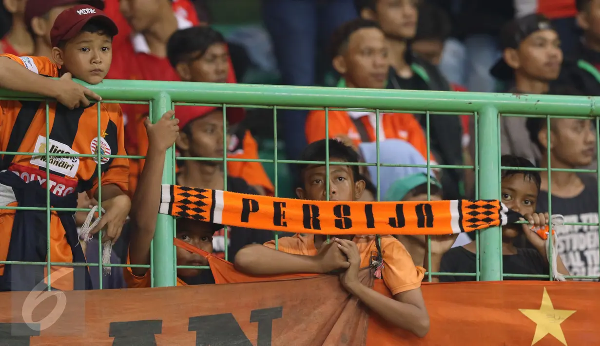 Suporter Persija termangu saat menyaksikan timnya berlaga melawan Madura United FC pada lanjutan Liga 1 di Stadion Patriot Candrabhaga, Bekasi, Kamis (4/5). Persija kalah 0-1. (Liputan6.com/Helmi Fithriansyah)