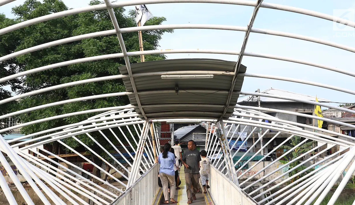 Pejalan kaki melintasi jembatan penyeberangan orang (JPO) Jayakarta yang atapnya rusak dan hilang di Menteng, Jakarta, Jumat (11/1). Kondisi JPO yang rusak mengganggu kenyamanan pejalan kaki. (Liputan6.com/Immanuel Antonius)