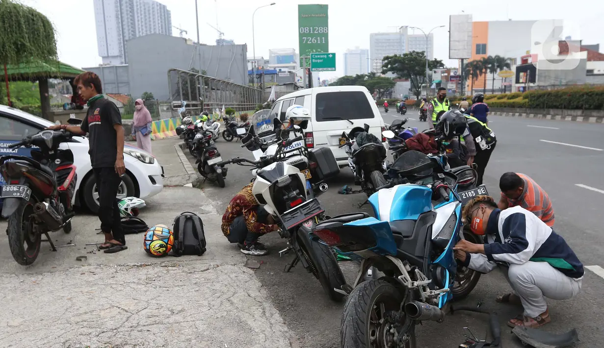 Pengendara motor mencopot knalpot bising usai terjaring razia yang digelar Satlantas PolresMetro Depok di Jalan Margonda Raya, Depok, Kamis (18/3/2021). Puluhan motor berknalpot bising yang terjaring razia diwajibkan mengganti knalpot dan diberi sanksi tilang. (Liputan6.com/Helmi Fithriansyah)