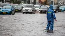 Warga melintasi genangan air di kawasan Bunderan HI, Jakarta, Kamis (22/11). Genangan air hujan setinggi 40 cm tersebut disebabkan hujan deras yang melanda Jakarta pada siang hari. (Liputan6.com/Faizal Fanani)