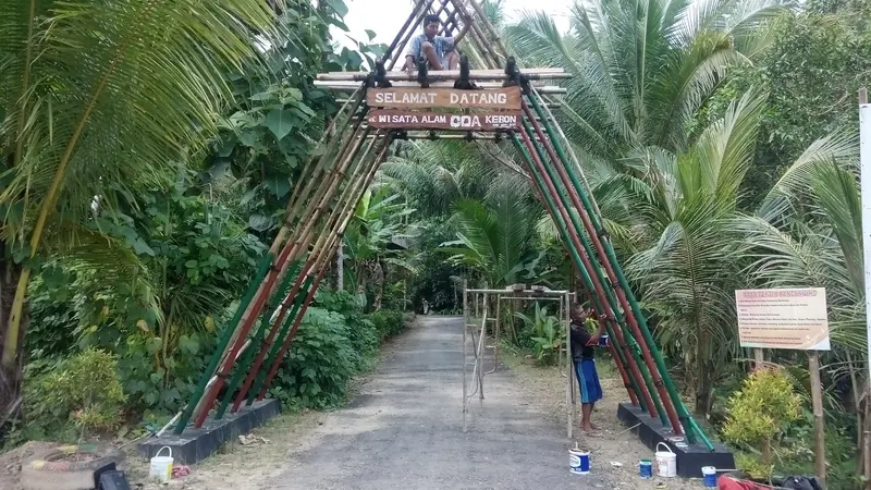 Seorang warga tengah membangun pintu masuk Goa Kebon dari Bambu