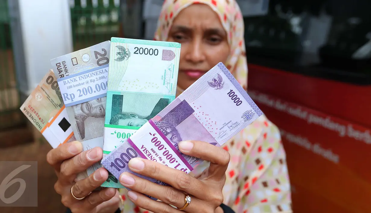 Warga menunjukkan uang kertas usai ditukarkan di penukaran uang keliling di Lapangan IRTI Monas, Jakarta, Senin (13/6). BI dan 20 bank umum lainnya membuka pelayanan penukaran uang di Monas yang dimulai 10 Juni 2016 kemarin. (Liputan6.com/Angga Yuniar)