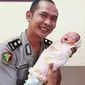 Bayi dibuang orang tuanya ditimang polisi yang bertugas di RS Bhayangkara Pekanbaru. (Liputan6.com/M Syukur)