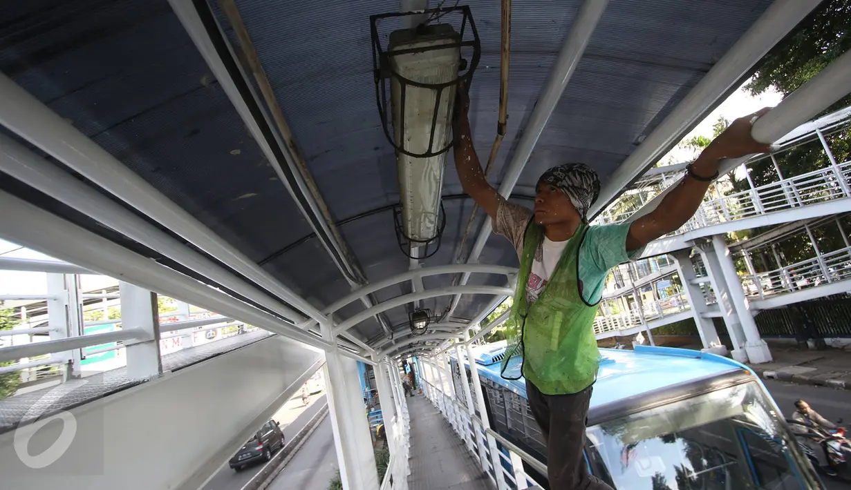 Pekerja mengecat jembatan penyeberangan menuju halte Transjakarta di kawasan Cawang, Jakarta, Rabu (5/4). Pengecatan dilakukan untuk menjaga halte agar tetap bersih dan terawat. (Liputan6.com/Immanuel Antonius)