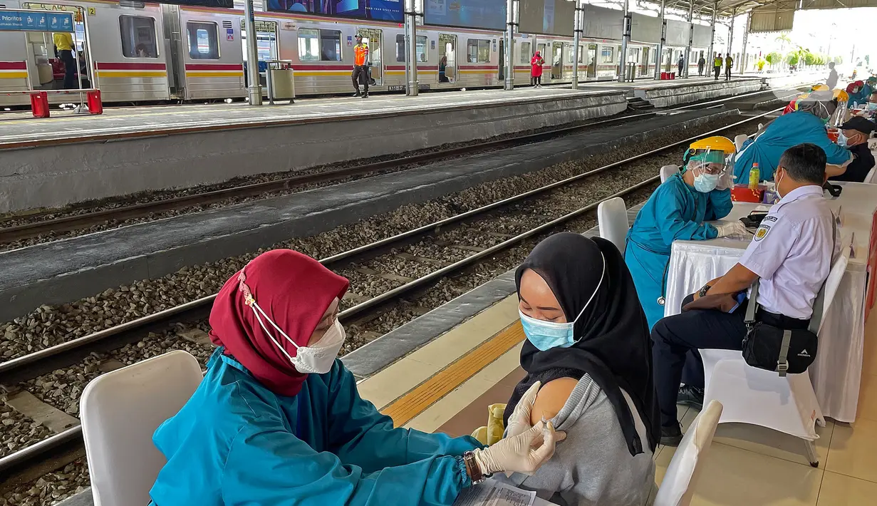 Tenaga medis menyuntikkan vaksin kepada petugas dan penumpang kereta api di Stasiun Bogor, Jawa Barat, Kamis (17/6/2021). Pelaksanaan vaksinasi massal di Stasiun Bogor itu menyasar petugas stasiun, pekerja di stasiun dan penumpang kereta. (Liputan6.com/Herman Zakharia)