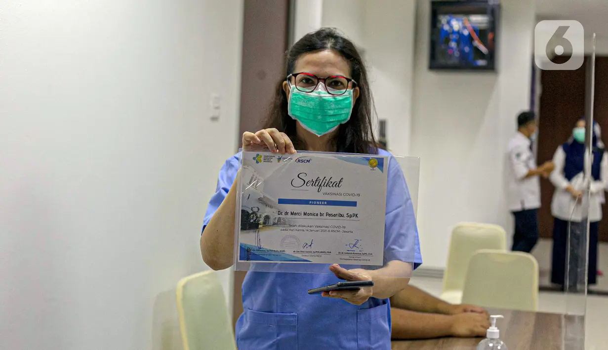 Tenaga kesehatan menunjukkan sertifikat usai menjalani vaksinasi virus corona COVID-19 di RSCM, Jakarta, Kamis (14/1/2021). Tenaga kesehatan menjadi prioritas utama pada program vaksinasi COVID-19 tahap awal. (Liputan6.com/Faizal Fanani)