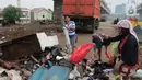 Warga memilah sampah sisa banjir yang menumpuk di kawasan Cipinang Melayu, Jakarta, Rabu (8/1/2020). Banjir yang melanda Jakarta dan sekitarnya sejak 1 Januari 2020 lalu menyisakan tumpukan sampah di sejumlah titik. (Liputan6.com/Herman Zakharia)